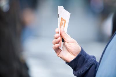 Person's hand holding event tickets